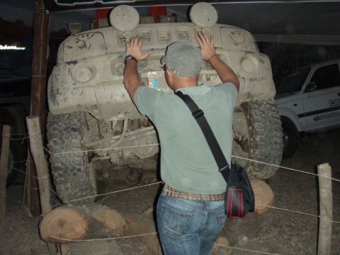 1995 Ford F-150 - A person interacts with a heavily soiled off-road vehicle, with another vehicle partially visible in the background.