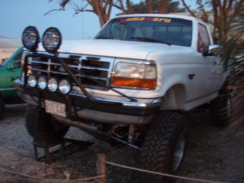 1995 Ford F-150 - 1995 Ford F-150 pickup truck modified for off-road use, parked outdoors.