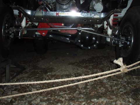 1995 Ford F-150 - Close-up view of the front axle and suspension of a truck, with a visible 'Kauffman' branded component.
