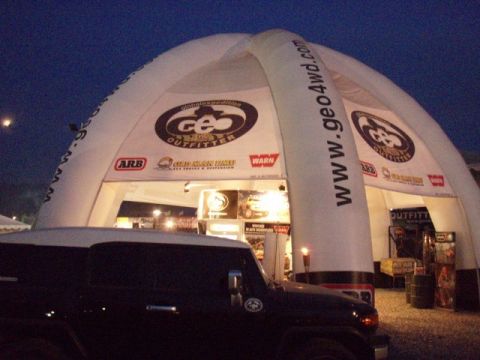 1995 Ford F-150 - SUV in front of a GEO Outfitter inflatable structure at dusk.
