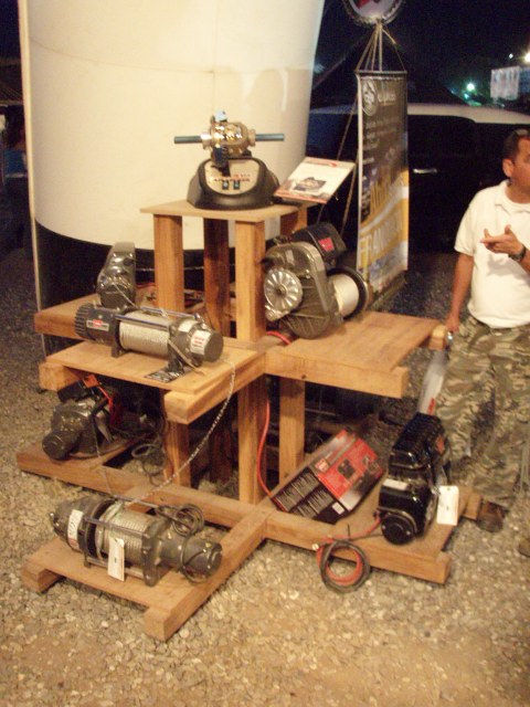 1995 Ford F-150 - A collection of winches are presented on a multi-level wooden display stand, with a person visible in the background.
