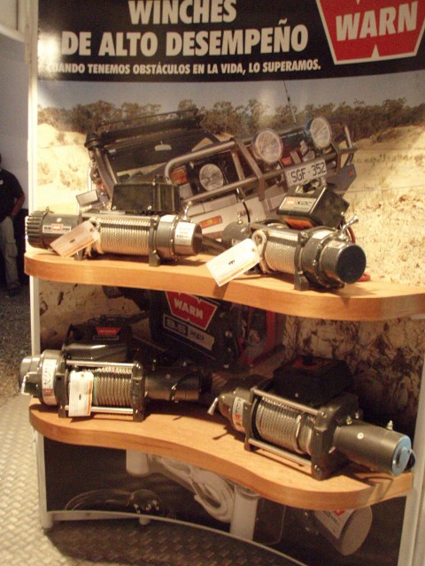 1995 Ford F-150 - Warn winches are displayed on shelves with a banner that reads 'Winches de Alto Desempeño'.