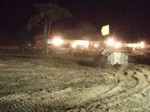 1995 Ford F-150 - A truck navigates a muddy course under bright lights at night.