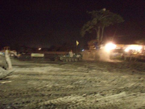 1995 Ford F-150 - A tracked vehicle with a person driving and a yellow flag is seen at night.
