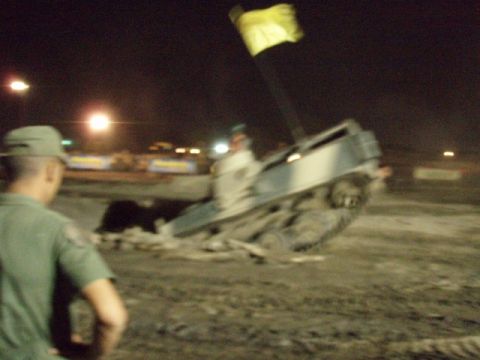 1995 Ford F-150 - A truck is overturned on a dirt track at night, with a yellow flag visible.