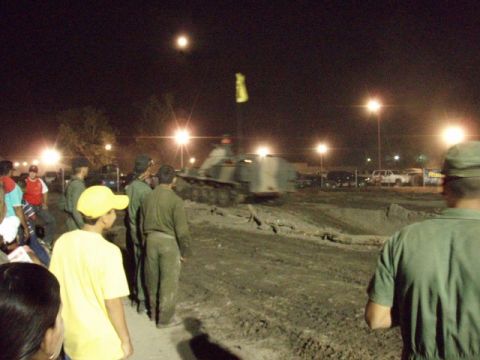 1995 Ford F-150 - A military vehicle navigates a muddy track at night while onlookers observe the event.