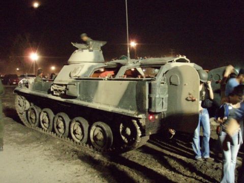 1995 Ford F-150 - An armored personnel carrier is parked outdoors at night, with several people gathered nearby.