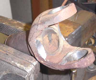 1992 Ford Explorer - A cracked universal joint is held in a vise, showing signs of wear and damage.