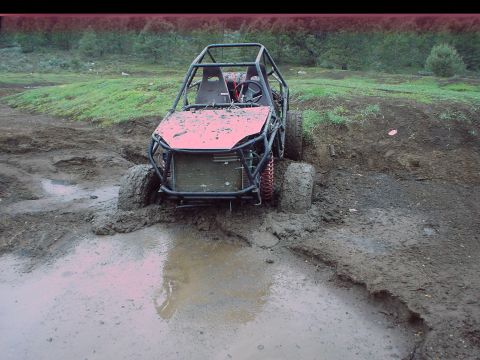 1984 Ford Bronco - This off-road buggy is deeply stuck in a muddy terrain, with its front tires barely visible.