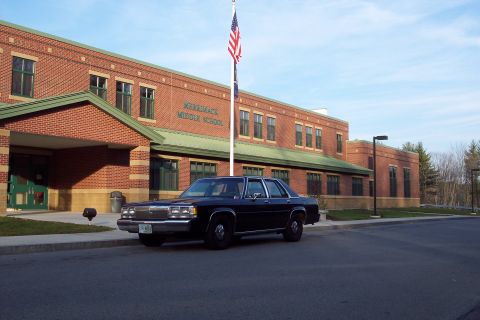2001 Ford Crown Victoria - A dark sedan is parked in front of Merrimack Middle School.