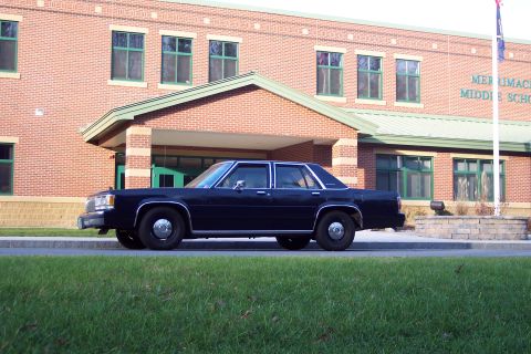 2001 Ford Crown Victoria - Side view of a dark sedan parked in front of Merrimack Middle School.