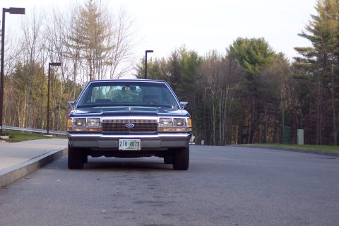 2001 Ford Crown Victoria - This dark blue sedan, identified as a 1991 Ford LTD, is seen from the front with its license plate clearly visible.