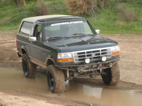 1995 Ford Bronco - This 1995 Ford Bronco, seen here in a three-quarter front view, navigates through a muddy terrain.