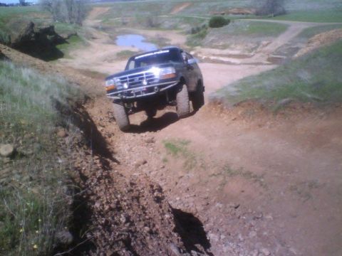 1995 Ford Bronco - Ford Bronco tackling rough terrain on a dry, dusty trail.