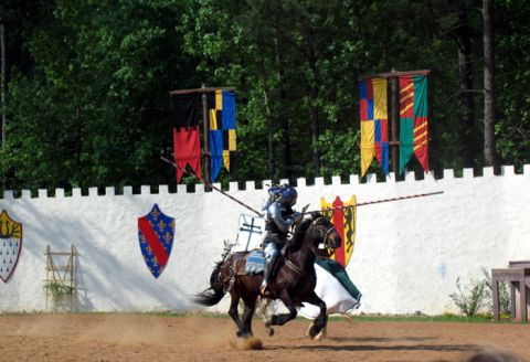 1995 Ford C-350 (Centurion Conversions) - A knight participates in a jousting tournament, with colorful banners and a castle-like wall in the background.