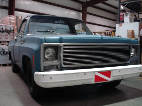 1979 Chevrolet C/K Pickup - Front view of a 1979 Chevrolet C/K Pickup truck with a chrome grille and a dive flag sticker on the bumper.