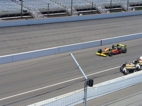 1991 Ford Probe - A race car speeds down the track, with spectator stands visible in the background.