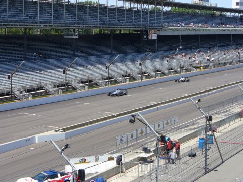 1991 Ford Probe - Two IndyCars compete on a race track, with empty grandstands visible in the background.