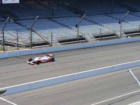 1991 Ford Probe - A single race car speeds around a track with empty stadium seating in the background.