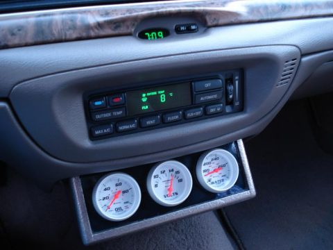 1999 Ford Crown Victoria - Interior view of a 1999 Ford Crown Victoria, climate controls and added gauges for oil, volts, and water temperature.