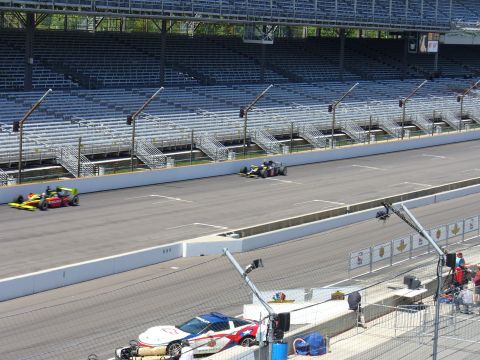 1991 Ford Probe - Race cars speed down the track with empty seats in the background and a police car in the foreground.