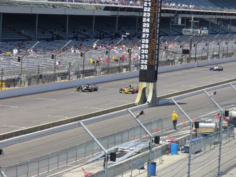 1991 Ford Probe - Race cars compete on a track with a large scoreboard displaying lap times and numbers.