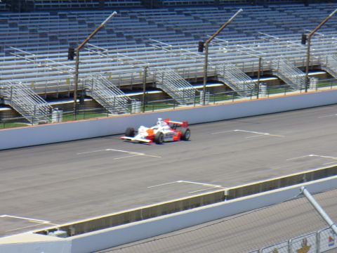 1991 Ford Probe - An open-wheel race car speeds around a track with empty grandstands visible.