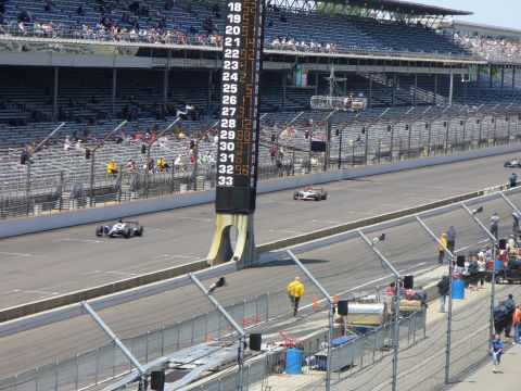 1991 Ford Probe - Race cars compete on a track with a large scoreboard displaying lap times and spectators in the stands.
