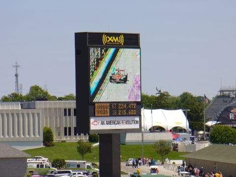 1991 Ford Probe - A large screen displays a racing car, current lap time, and speeds, along with a Chevrolet advertisement.