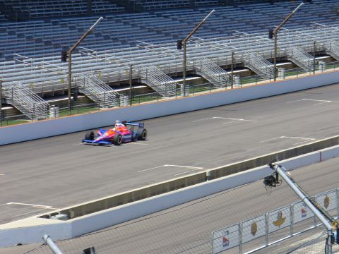 1991 Ford Probe - An IndyCar races on a track with empty grandstands visible in the background.