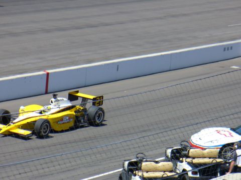 1991 Ford Probe - A yellow and white race car speeds down the track, with another vehicle in the foreground.