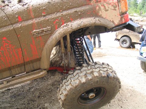 1989 Ford Bronco - A heavily mud-covered 1989 Ford Bronco shows off its lifted suspension and large off-road tires during an off-road event.