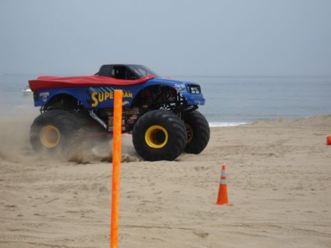 1996 Ford Bronco - Monster truck with Superman theme driving on the beach near the ocean.