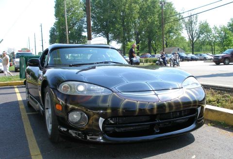 1998 Ford Crown Victoria - A black Dodge Viper is parked in a lot, custom snake-themed airbrushing on its exterior.