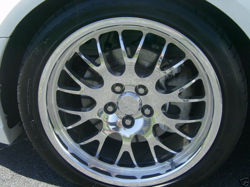 Close-up of a chrome alloy wheel with a black tire. The wheel has a multi-spoke design