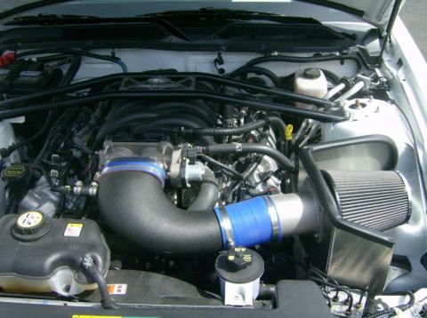 2007 Ford Mustang - Engine bay of a white car, showing an aftermarket intake system and other engine components.