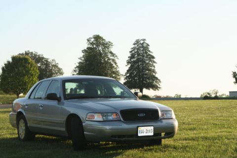 2004 Ford Crown Victoria - A silver 2004 Ford Crown Victoria is parked outside on a sunny day.