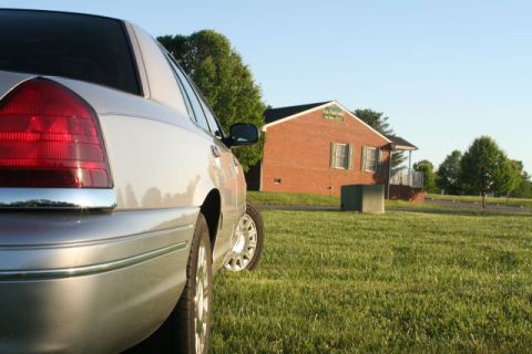 2004 Ford Crown Victoria - Silver 2004 Ford Crown Victoria parked on a lawn with a brick building in the background.