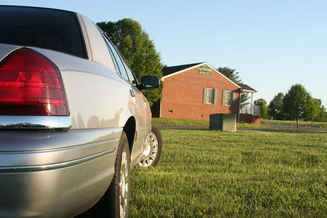 Rear quarter panel of a silver 2004 Ford Crown Victoria parked on a grassy lawn