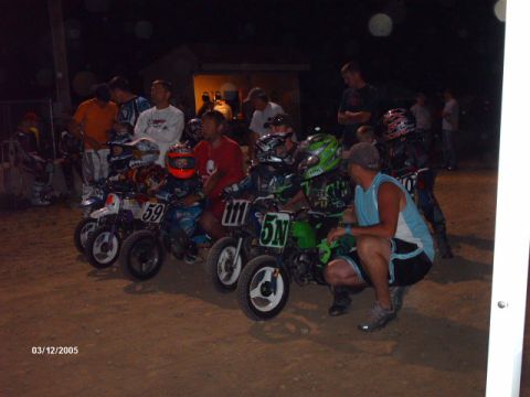 1995 Ford Probe - Children and adults gather around mini dirt bikes at a nighttime event.