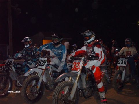 1995 Ford Probe - Motorcyclists prepare for a race at night, with visible numbers on their bikes.