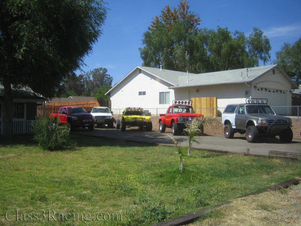 Off-road trucks parked in driveway of a house