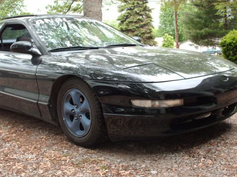 1995 Ford Probe - A black Ford Probe is shown from the front 3/4 angle, parked outdoors on a gravel surface.
