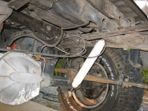1989 Ford Bronco - The underside of a vehicle reveals a "Rockcrusher" differential cover and suspension components.