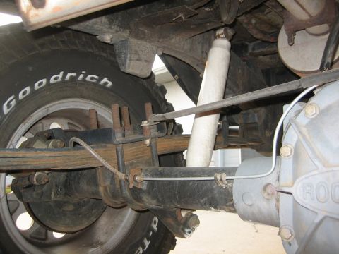 1989 Ford Bronco - Close-up of the rear suspension and axle assembly, showing leaf springs and a shock absorber.