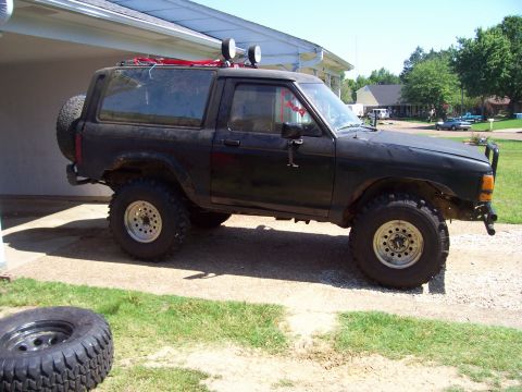 1989 Ford Bronco II - Modified 1989 Ford Bronco II SUV with off-road tires and roof lights.