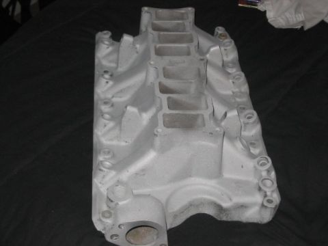 1991 Ford Bronco - An intake manifold, likely for a V8 engine, is shown from a top-down perspective against a dark background.