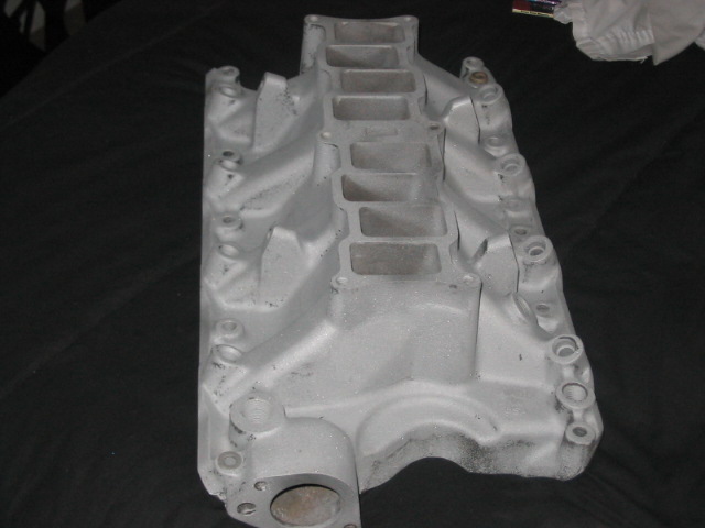 Aluminum intake manifold with eight intake ports and a central carburetor mounting area