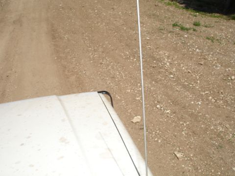 1989 Ford Bronco - A white 1989 Ford Bronco is seen from above, driving on a dusty dirt road.