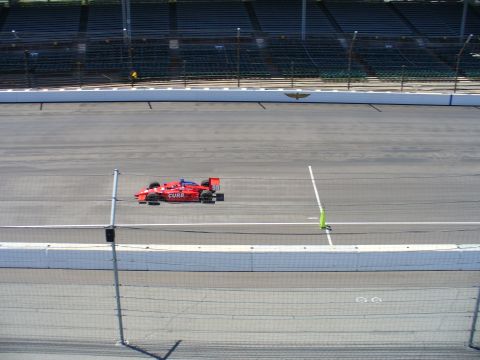 1991 Ford Probe - A single red race car drives on a paved track with empty grandstands visible in the distance.